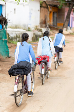 Young girls going to school by bicycle in India