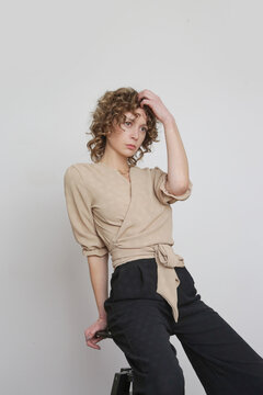 Series of studio photos of young female model in beige and black linen outfit.	