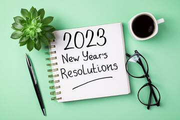 New year resolutions 2023 on desk. 2023 resolutions list with notebook, coffee cup on table. Goals,...