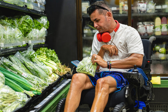 Horizontal Image Inside A Supermarket Of A Disabled Gay Man Shopping For Some Vegetables Alone.