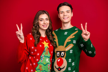 Photo of positive couple wife husband wear ugly sweaters demonstrate v-sign rejoice time together...