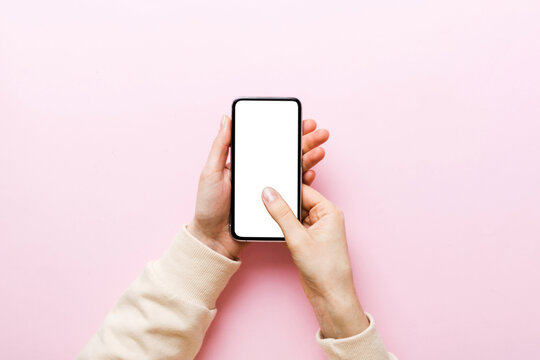 Top view of woman hands holding smart phone with blank copy space screen for your text message or information content. woman hand using phone white screen on top view