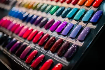 Tuinposter Set of many colorful palletes of gel nail polishes on counter of make up store, manicure salon, exhibition - close up view. Fashion, care, cosmetic, beauty, makeup and glamour concept © zyabich