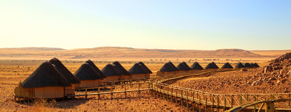 Souss Dune Lodge, Namibia, 2022.  Luxury accommodation in the desert, with thatched rondavels reached by wooden walkway with amazing views. This is the only camp situated inside Sossusvlei