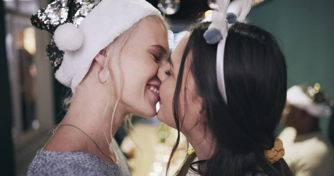 Christmas party, lgbtq couple and kiss, love and romantic partner, celebration and happiness. Gay, lesbian and kissing young women celebrate festive xmas holidays together at social gathering event