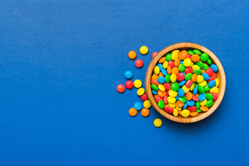 Multicolored candies in a bowl on a colored background. birthday and holiday concept. Top view with...