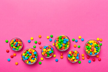 different colored round candy in bowl and jars. Top view of large variety sweets and candies with copy space