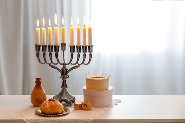 Jewish holiday Hanukkah with menorah (traditional Candelabra), donuts and wooden dreidels (spinning top), chocolate coins.  Inscription on the menorah "Olive oil"