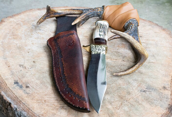 View of a Hunting handmade Bowie Knife with deer antlers and leather sheath - obrazy, fototapety, plakaty
