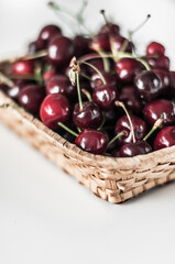 Wicker basket with fresh fragrant cherry closeup.