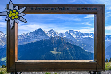 Wooden frame with a view on the mountain range Eiger Moench and Jungfrau in the Swiss alps - obrazy, fototapety, plakaty