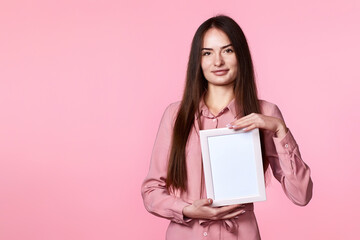 young woman in pink dress holding white frame