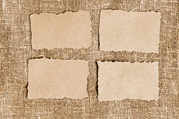 Recycled craft paper pieces on jute background. Brown torn paper, ripped scraps of paper on sackcloth background