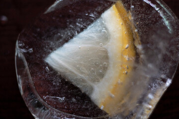 a piece of lemon frozen in a piece of ice	
