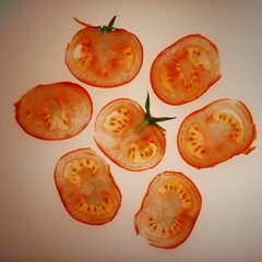 Flat lay of tomato slices on an off-white background