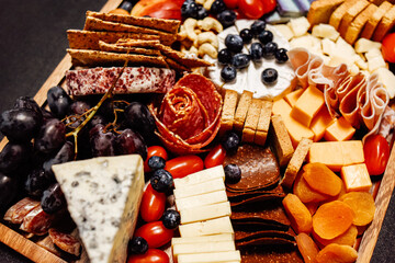 Cheese platter, cheese board meat and board. Vegetables and fruits with cheese and chocolate, prosciutto and salami with bread. Big board of snacks for the party.