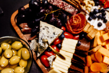 Cheese platter, cheese board meat and board. Vegetables and fruits with cheese and chocolate,...