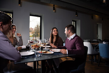 Fototapeta premium Group of Happy friends having lunch in the restaurant