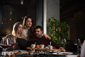 Happy business colleagues talking while eating dinner in a restaurant