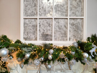 a beautiful Christmas tree garland hangs over the fireplace