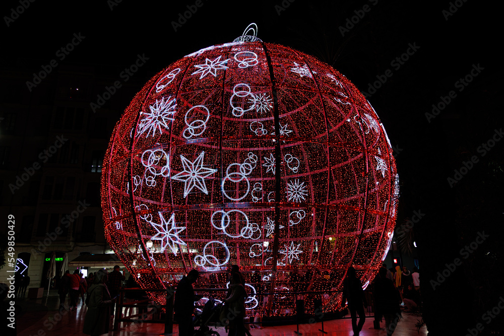 Wall mural big glowing red bauble christmas decoration in alicante, spain at night