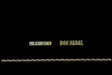  golden shiny neon inscription merry christmas on a black background in Spanish and Catalan, Valencian