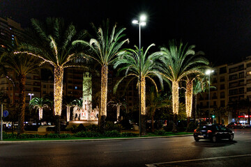Fototapeta na wymiar Luceros square in Alicante at night with decorative palm trees for Christmas