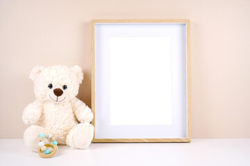 Artwork picture frame product mockup. Baby shower 1st birthday Christening gender neutral party. Styled setting with white teddy bear against a beige and white background. Negative copy space.