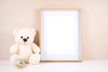 Artwork picture frame product mockup. Baby shower 1st birthday Christening gender neutral party. Styled setting with white teddy bear against a beige and white background. Negative copy space.