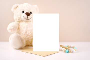 5x7 vertical greeting card party invitation product mockup. Baby shower birthday christening gender neutral. Styled with white teddy bear against a beige and white background. Negative copy space.