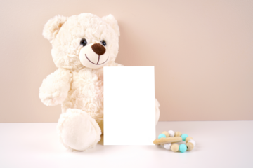 4x6 vertical greeting card party invitation product mockup. Baby shower birthday christening gender neutral. Styled with white teddy bear against a beige and white background. Negative copy space.