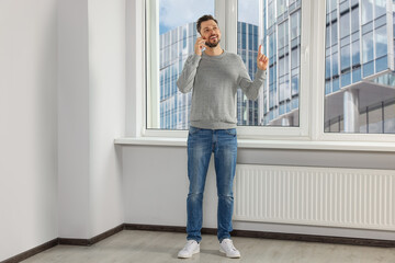 Fototapeta premium Man talking on phone near window indoors