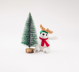 New Year Christmas tree with plush polar bear and reindeer antlers on a white background.