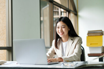 Young asian business woman or student working online on computer