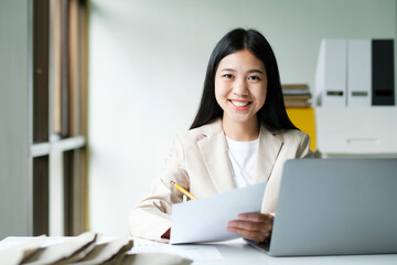Young asian business woman or student working online on computer