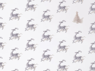 Silver decorative reindeer with glitter Christmas tree on a white background. Pattern.