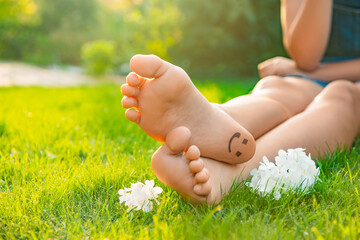 Teenage girl with beautiful hortensia flowers and smiling face drawn on heel outdoors, closeup....