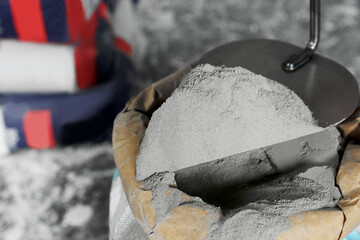 Cement powder and trowel put in bag, closeup