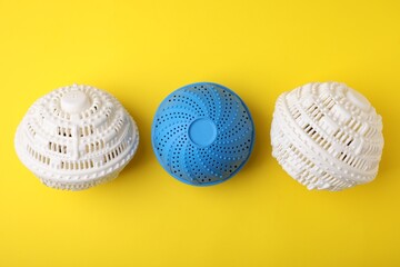 Dryer balls for washing machine on yellow background, flat lay