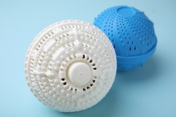 Dryer balls for washing machine on light blue background, closeup
