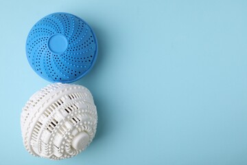 Laundry dryer balls on light blue background, flat lay. Space for text