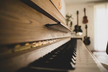 Selective focus on the black and white piano keys placed inside a room