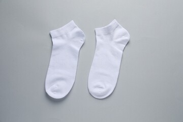 Pair of white socks on light grey background, flat lay
