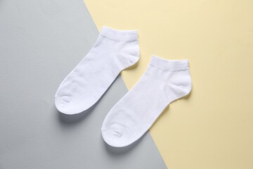 Pair of white socks on colorful background, flat lay