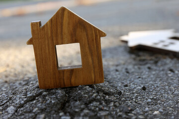 Obraz na płótnie Canvas Wooden house model on cracked asphalt. Earthquake disaster