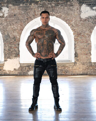 Muscular athletic sexy male with naked torso. Brutal handsome man with tattooed body. Stylish man. A beautiful and charming guy