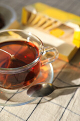 Tea bag in glass cup on table, closeup