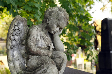 Beautiful statue of angel at cemetery on sunny day, space for text. Funeral ceremony