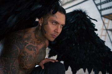 man portrait. Close up portrait of handsome male angel. Guy with tattoo. hot man in leather . man with collar and whip. Angle with dark wings