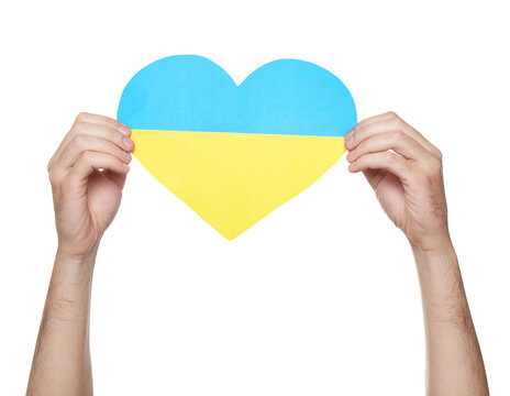 Man holding paper heart in colors of Ukrainian flag on white background, closeup